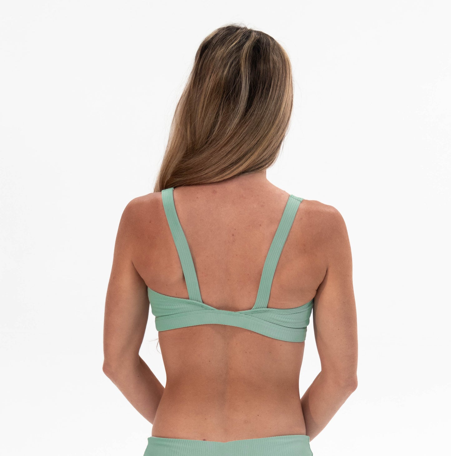 the back of a woman in a green bikini top